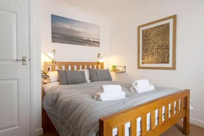 a bedroom with a large bed with two towels on it at 3 Victoria House in St Ives