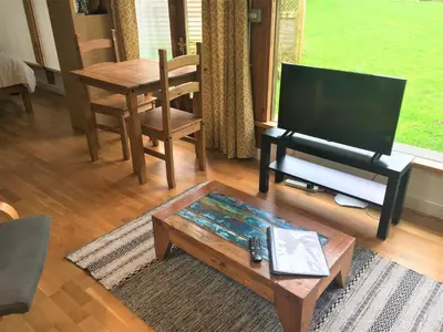 a living room with a television and a coffee table at Jopes Mill and Lodge in Looe