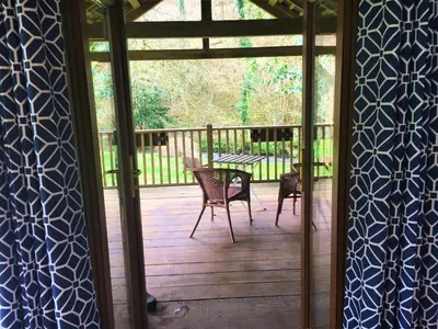a screened in porch with a table and chairs at Jopes Mill and Lodge in Looe
