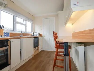 a kitchen with white cabinets and a counter top at Summer Breeze in Padstow
