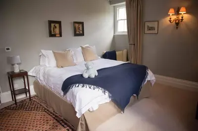 a bedroom with a bed with a teddy bear on it at The Manor House at Boconnion in Bodmin