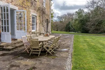a table and chairs sitting outside of a house at The Manor House at Boconnion in Bodmin
