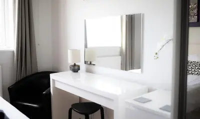 a bedroom with a white vanity with a mirror and a chair at Stunning Sea Views, luxury apartment beaches & restaurants are a short walk away in Newquay