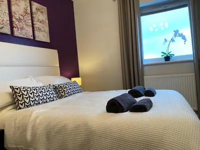 a bed with blue towels on it with a window at Stunning Sea Views, luxury apartment beaches & restaurants are a short walk away in Newquay
