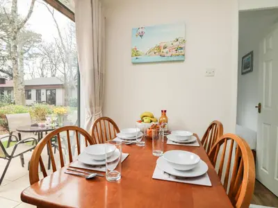 a dining room with a wooden table and chairs at Miles Retreat in Hayle