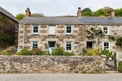 an old stone house with a stone wall at Navas Nook in Falmouth