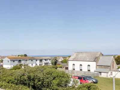 a small white house with a red van parked in front of it at Eloen in Newquay