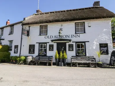 an oldaiden inn with two benches in front of it at No 1 The Hinges in Newquay