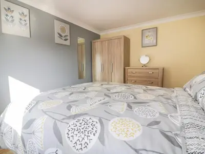 a bedroom with a large bed with a gray and white bedspread at Lower Brambleside in Truro