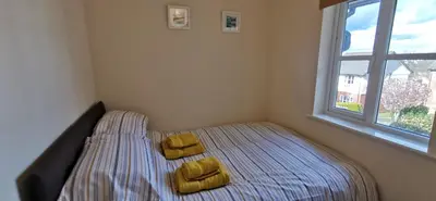 a small bedroom with a bed with two yellow pillows at The Honeypot - Cornish Apartment close to Eden Project & beaches in Par