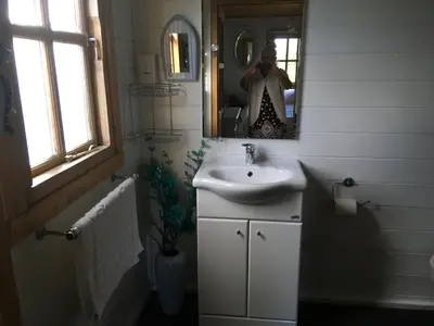 a person taking a picture of a bathroom with a sink at Trevenna Cabin in St Austell