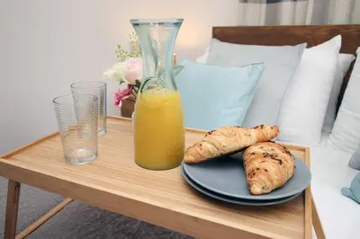 a table with a plate of food and a glass of orange juice at The Cornish Nook Beautiful Grade 2 Listed Building In Cornwall By STAE-Homes in Camelford