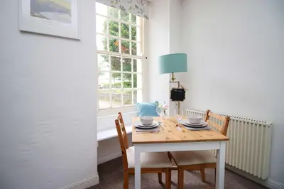 a table with two chairs and a blue lamp on it at The Cornish Nook Beautiful Grade 2 Listed Building In Cornwall By STAE-Homes in Camelford