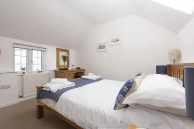 a bedroom with two beds and a window at Dolor Cottage in Coverack