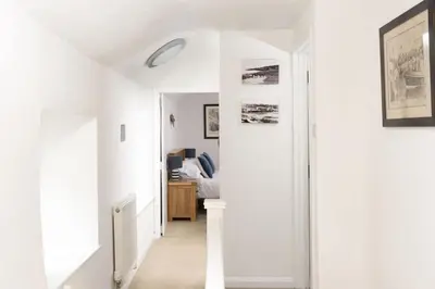 a hallway with white walls and a white ceiling at Dolor Cottage in Coverack
