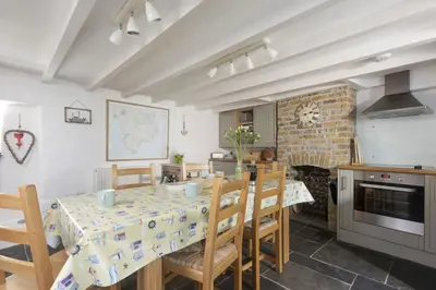 a kitchen and dining room with a table and chairs at Dolor Cottage in Coverack