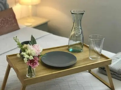 a wooden tray with a plate and a vase and glasses at The Cornish Peak Beautiful Apartment In Grade 2 Listed Building In Cornwall By STAE-Homes in Camelford