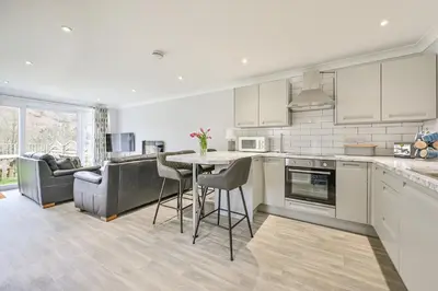 a kitchen with a table and chairs and a couch at 2 Bed Villa Sleeps 4 - Wifi Garden Sea Views in Looe