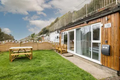 a patio with a picnic table and a building at 2 Bed Villa Sleeps 4 - Wifi Garden Sea Views in Looe