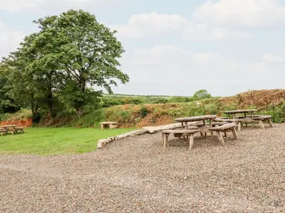 a group of picnic tables on top of a field at The Cornstore in Bodmin