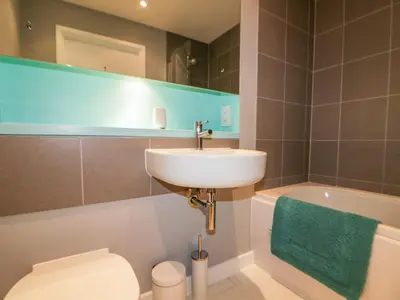 a bathroom with a sink and a toilet and a tub at 23 Tre Lowen in Newquay