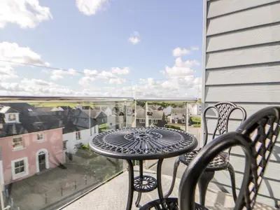 a table and chairs on a balcony with a view at 23 Tre Lowen in Newquay