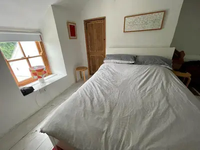 a bed in a bedroom with a window at Mapa Cottage in Mount Hawke
