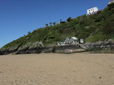 a beach with houses on top of a hill at Estuary View in Newquay