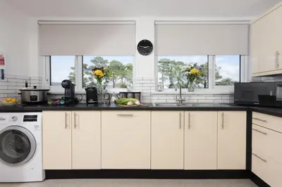 a kitchen with a sink and a washing machine at Bridge Apartment - Free Parking & WiFi - Near Perranporth Beach in Perranporth