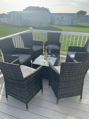 a group of wicker chairs and a table on a deck at Bude 13 in Cubert