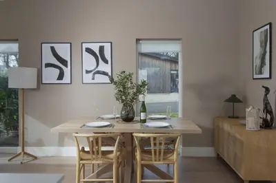 a dining room with a table with chairs and a bottle of wine at Salt Life, Dunes at Upton Towans - Hot tub - Pet friendly - Self check in in Hayle