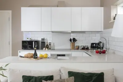 a kitchen with white cabinets and a counter top at Salt Life, Dunes at Upton Towans - Hot tub - Pet friendly - Self check in in Hayle