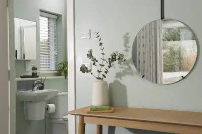 a bathroom with a sink and a mirror and a table at Salt Life, Dunes at Upton Towans - Hot tub - Pet friendly - Self check in in Hayle