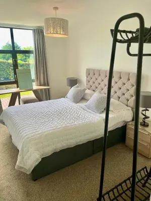 a bedroom with a bed with a white comforter at Pochin House Collections in St Austell