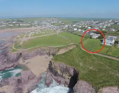 a house on a cliff next to a beach at Gullsway Kittiwake in Polzeath