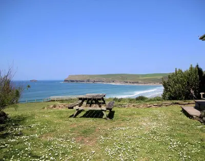 a picnic table sitting on the grass near the beach at Gullsway Kittiwake in Polzeath
