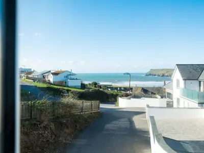 a view of a beach with houses and the ocean at Pinewood Flat 5 in Polzeath