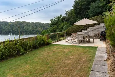 a patio with a table and chairs and an umbrella at Finest Retreats - Tideway in Saint Clement