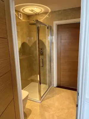 a glass shower in a bathroom with a toilet at Hewas Water House - Private Pool, Hot Tub & Games Room in Grampound