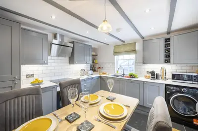 a kitchen with a wooden table with yellow plates on it at The Hideaway in Porthleven