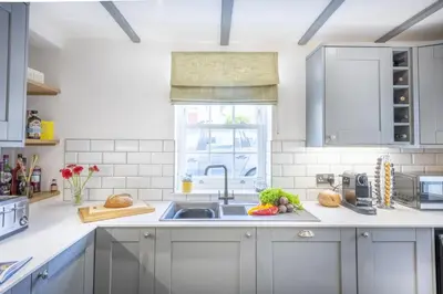 a white kitchen with a sink and a window at The Hideaway in Porthleven