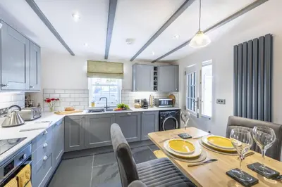 a kitchen with a wooden table and chairs in a kitchen at The Hideaway in Porthleven
