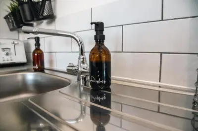 a bottle of wine sitting on a kitchen sink at Valley View Studio Annexe in Downderry
