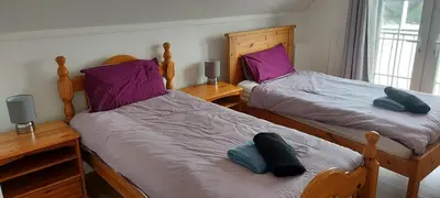 two twin beds in a room with purple pillows at Nice big 2 double bedroom Apartment in the Town in Newquay