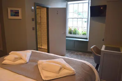 a bedroom with a bed with white towels on it at Crown Inn in Penzance