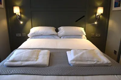 a large bed with two towels on top of it at Crown Inn in Penzance