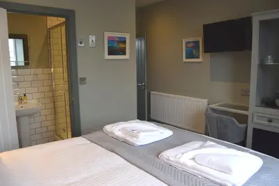 a bedroom with a bed with two towels on it at Crown Inn in Penzance