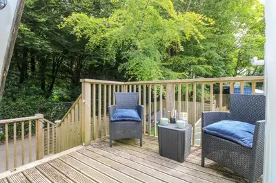 two chairs and a table on a wooden deck at Robin's Nest at The Shire Inn in Camborne