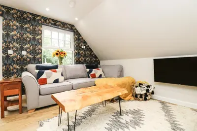 a living room with a couch and a tv at Robin's Nest at The Shire Inn in Camborne