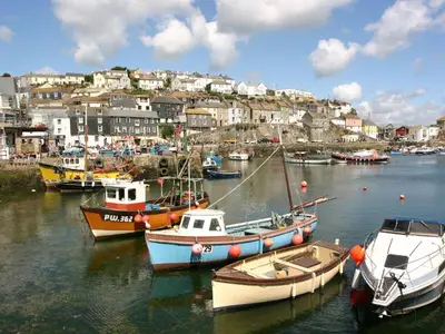 a group of boats are docked in a harbor at 12 Claremont Falls in Looe